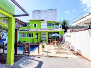 ein grünes Haus mit einem Pool und einer Terrasse in der Unterkunft casa com piscina in Ubatuba