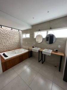 a bathroom with two sinks and a bath tub at Casa exclusiva, próximo à Maceió. in Paripueira