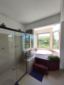a bathroom with a tub and a large window at Chalé Jenipapo in Santana do Riacho