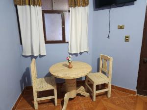a table and two chairs in a room at Hotel Aguilar in Uyuni