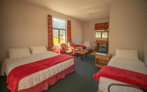 a hotel room with two beds and a desk at Ropatinis Bed & Breakfast in Fox Glacier