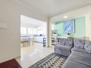 a living room with a couch and a kitchen at casa com piscina in Ubatuba