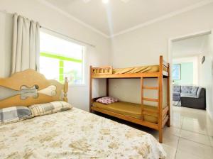 ein Schlafzimmer mit einem Etagenbett und einem Fenster in der Unterkunft casa com piscina in Ubatuba