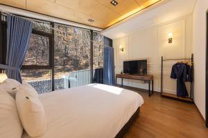 a bedroom with a large bed and a large window at Private Pool Villa with filled with stars in Ulsan