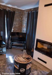 a living room with a fireplace and a tv at Triantos Guesthome Suite in Tripolis