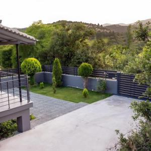 un jardín con un banco y árboles en el fondo en Triantos Guesthome Suite, en Tripolis