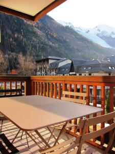 un tavolo su un balcone con vista sulle montagne di Evasion Sérénité à Chamonix Mont-Blanc a Chamonix-Mont-Blanc