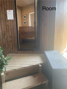 a door to a room with a bench and a mirror at Stay at the art gallery in Mapua