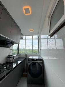 Il comprend une cuisine équipée d'une cuisinière et d'un lave-vaisselle. dans l'établissement Trival Luna Homestay Sri Indah Sandakan, à Sandakan