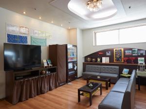 ein Wohnzimmer mit einem großen Flachbild-TV in der Unterkunft Hotel Yamanouchi in Naha