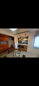 a living room with a table and a kitchen at Condominio Dumont in Canoas
