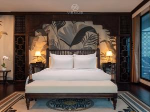 a bedroom with a bed with a painting on the wall at Venus Halong Cruises in Ha Long