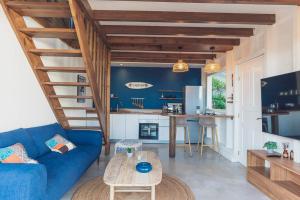 聖安妮的住宿－Cap Sud Bungalow du bourg près de la mer，客厅配有蓝色的沙发和桌子