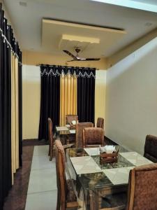 une salle à manger avec une table et des chaises en verre dans l'établissement Shree Nanda Guest House, à Varanasi