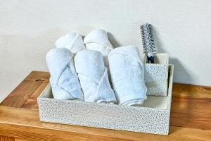 una caja de toallas plegadas sobre una mesa de madera en The Raon Pension, en Yeosu