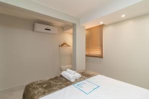 a bedroom with a bed with two towels on it at Residencial Oliveiras - Apartamento 3 in Brasilia
