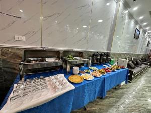 a buffet line with food on a blue table at TOMMY HOTEL in Cat Ba