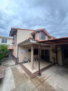 ein Haus mit einer großen Veranda mit einem Dach in der Unterkunft Casa bonita y cómoda in Santa Cruz de la Sierra