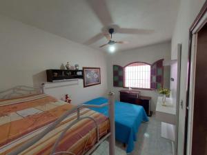 1 dormitorio con 1 cama y ventilador de techo en Uma jóia em frente ao mar!, en Piúma