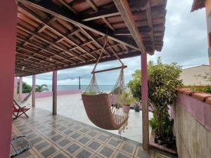 een hangmat hangend aan een pergola op een patio bij Uma jóia em frente ao mar! in Piúma