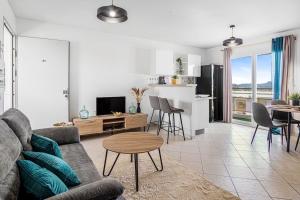 un soggiorno con un divano, un tavolo e una cucina di Appartement City View a Le Lamentin
