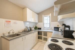 a kitchen with a sink and a stove top oven at Boutique Private Suite 7 Min Walk to Sydney Domestic Airport 2 - ROOM ONLY in Sydney