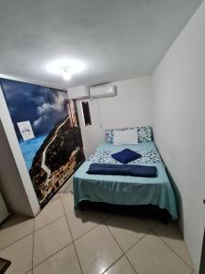 a bedroom with a bed with a picture on the wall at POUSADA DO HOSTEL in Jacobina