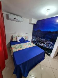 a small bedroom with a blue bed with a window at POUSADA DO HOSTEL in Jacobina