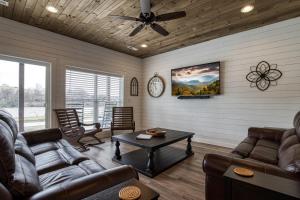 sala de estar con muebles de cuero y ventilador de techo en Lazy River Cabin - On The River, Wifi, Free Attraction Tickets!!!, en Kodak