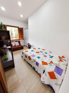 1 dormitorio con 1 cama con un edredón colorido en Casa familiar vacacional en Jardín