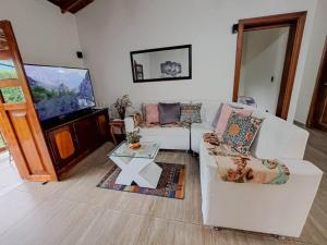a living room with two couches and a flat screen tv at Casa familiar vacacional in Jardin