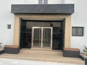 a building with a black facade with a glass door at Hôtel Esma Nouadhibou in Nouadhibou