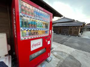 a cocacola soda vending machine in front of a building at Issyuku Ike Issyo En - Vacation STAY 86605v in Tabuchi