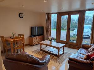 a living room with a couch and a table at Orchard Cottage in Bradley in the Moors