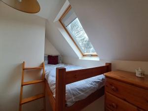 a bedroom with a bunk bed and a window at Orchard Cottage in Bradley in the Moors