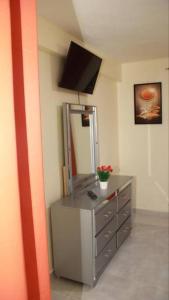 um quarto com uma cómoda com um espelho e uma televisão em SDQ Apartamento Marbella I em La Ureña