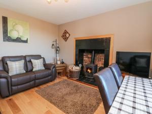 a living room with a couch and a fireplace at Marys House in Kilchoan