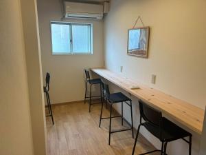 a room with a bar with stools in it at Hostel JAQ takamatsu in Takamatsu