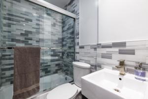 uma casa de banho com um WC, um lavatório e um chuveiro em Discover the Comfort of Columbia University Area em Nova York