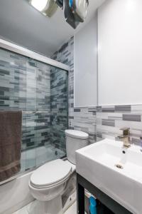uma casa de banho com um WC, um chuveiro e um lavatório. em Discover the Comfort of Columbia University Area em Nova York