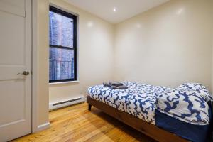 um quarto com uma cama e uma janela em Discover the Comfort of Columbia University Area em Nova York