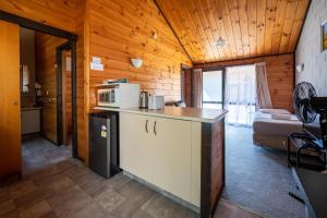 a kitchen with a refrigerator and a microwave in a room at Orewa Motor Lodge in Orewa