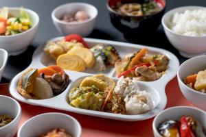 Hotel Vista Kumamoto Airport في Ozu: صينية من مختلف أنواع الطعام على طاولة