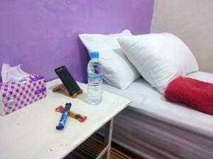 Aziz House 1 في طانطان: زجاجة مياه على طاولة بجوار سرير