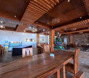 a large wooden table in a room with a christmas tree at The Blessed Purple Bamboo Beach Resort in Alaminos