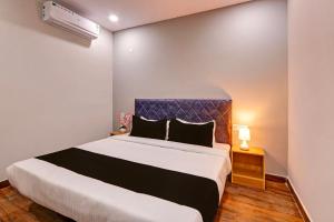 a bedroom with a large bed with a blue headboard at Super OYO Flagship RBS Classic Stay Boduppal in Hyderabad