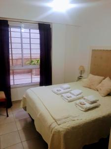 a bedroom with a bed with towels on it at A&S Mendoza in Barraquero