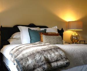 a bedroom with a bed with a blanket and a lamp at Barossa Bed & Breakfast in Tanunda