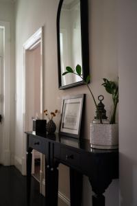 a black table with a mirror and plants on it at Barossa Bed & Breakfast in Tanunda