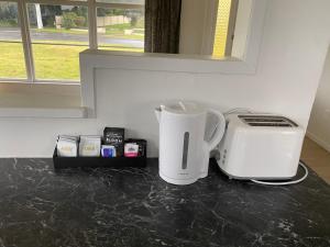 eine Arbeitsplatte mit einer Kaffeemaschine und einem Toaster in der Unterkunft Your Home in Rotorua 3 Frank Street in Rotorua